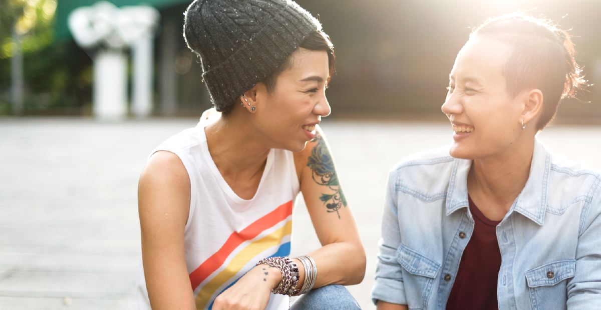 Two friends laughing together outdoors
