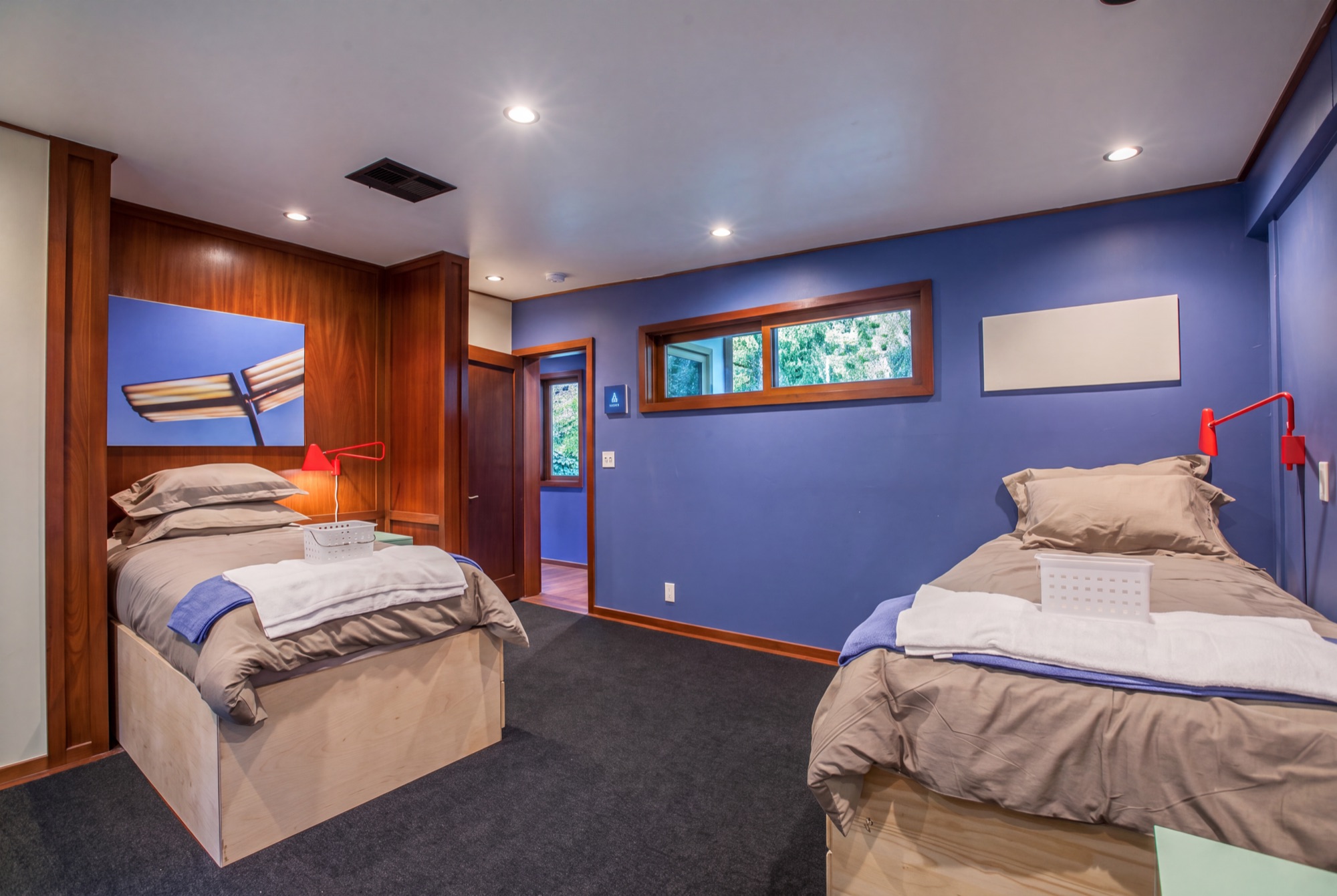 Twin beds with a calming blue accent wall